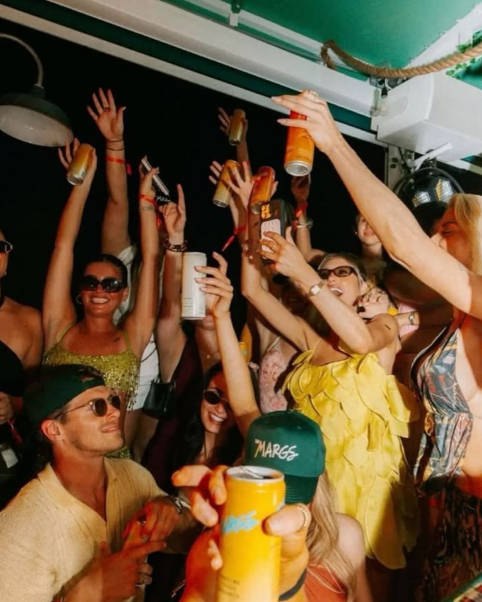 Gruppe hebt Drinks jubelnd in die Luft