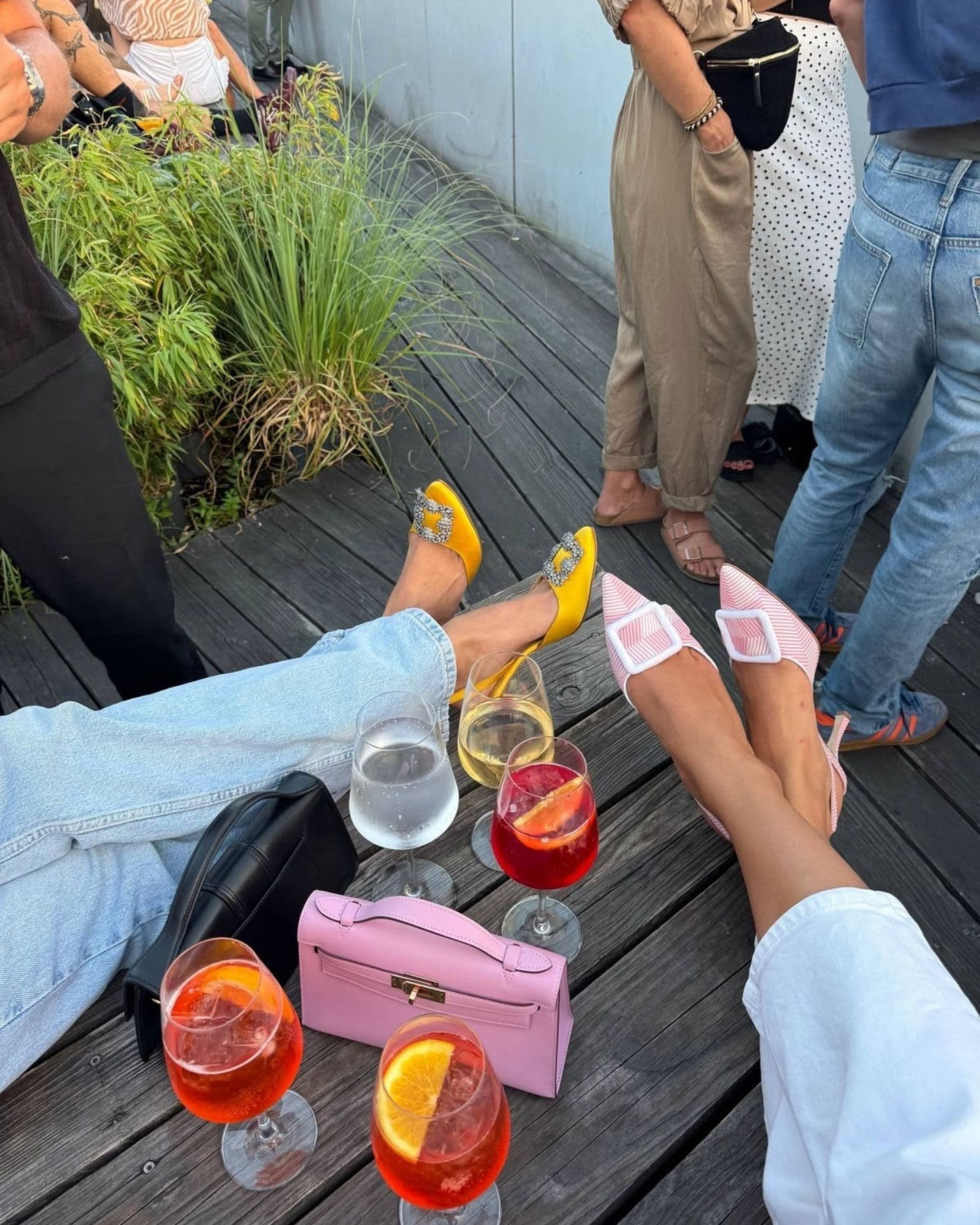 Füsse auf der Holzterrasse neben Spritz-Drinks
